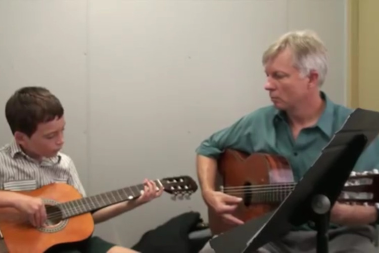 child having guitar lesson
