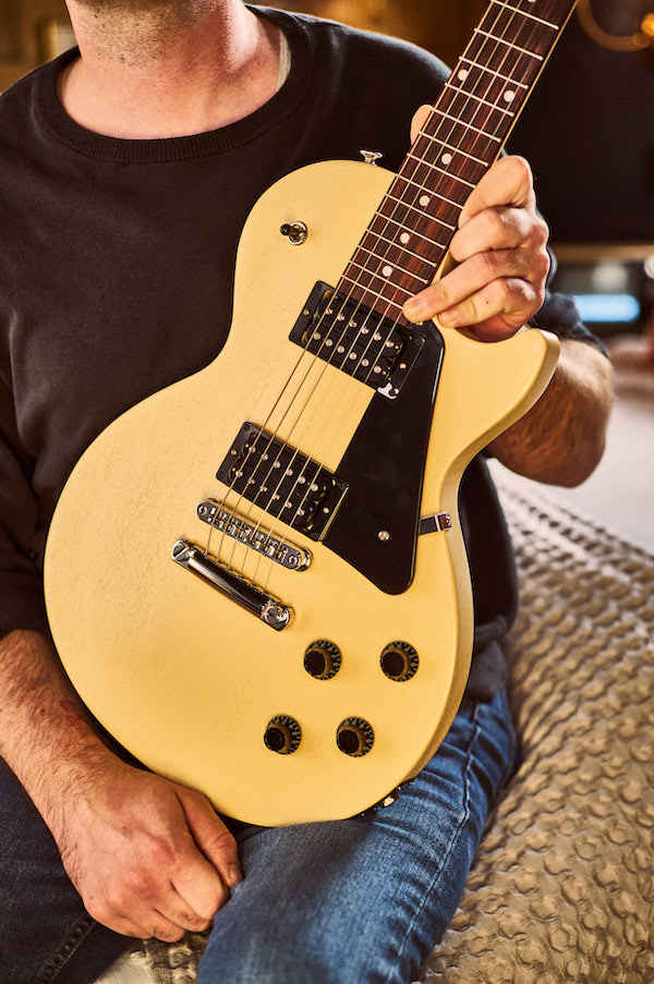 holding up a yellow gibson les paul modern lite